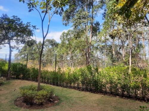 a fence with a tree in a park at Capão do Cerrado Pousada e Spa in Itabirito