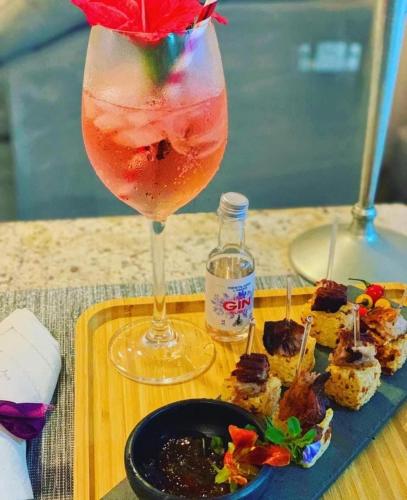 a drink in a glass next to a plate of food at Capão do Cerrado Pousada e Spa in Itabirito