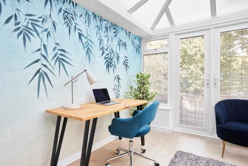 a home office with a desk and blue leaves wallpaper at Links to M62 - 3 bedroom property in Golcar