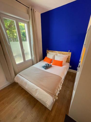 a bedroom with a bed with a blue wall at Studio design Bleu Alpin in Le Mont-Dore
