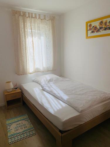 a bed in a bedroom with a window and a rug at Ferienwohnung im Spessart / Aschaffenburg in Johannesberg