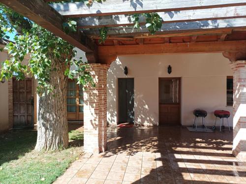 une entrée à une maison avec un arbre dans l'établissement Casas Olmo y Fresno jardín y piscina a 17 kilómetros de Salamanca, à Salamanque