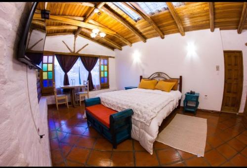a bedroom with a bed and a table and chairs at La Casa del colibri ecuador in Quito