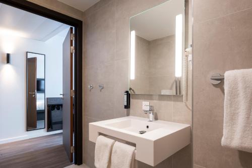 a bathroom with a white sink and a mirror at B&B HOTEL Antwerpen Centrum in Antwerp