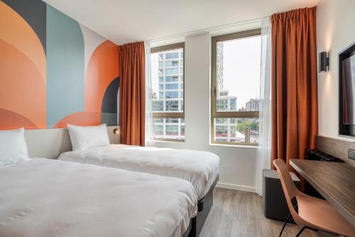 a hotel room with two beds and a desk at B&B HOTEL Antwerpen Centrum in Antwerp