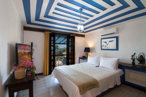 1 dormitorio con 1 cama y techo azul y blanco en Pousada do Adriano en Búzios
