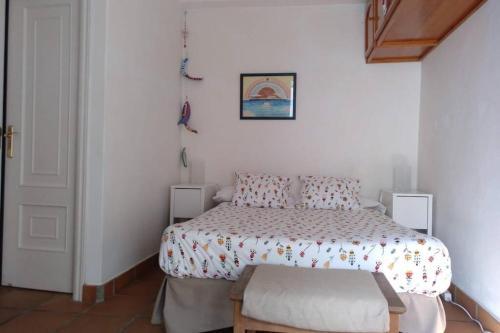 a small bedroom with a bed and a stool at Studio Askanova in Valle Gran Rey