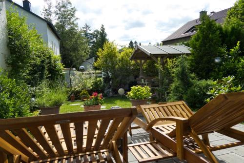 two wooden benches sitting on a patio at Gästehaus Guter Stern in Bad Steben