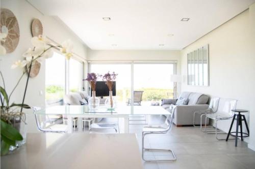 a white living room with a white table and chairs at Casa con vistas al mar con piscina in Porto Covo