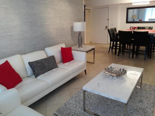 a living room with a white couch and a table at Resort Style In Aventura Florida in Aventura