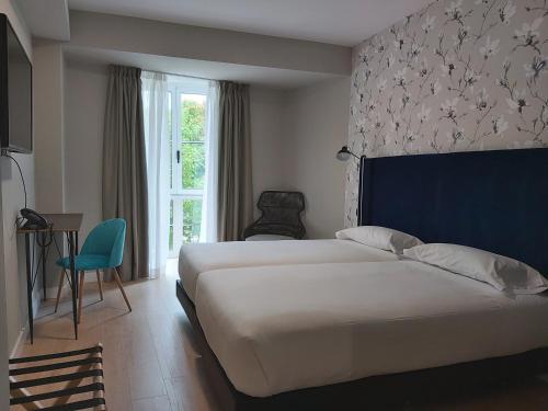 Una habitación de hotel con dos camas y una ventana. en Micampus Burgos Centro Student Residence, en Burgos