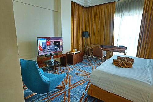 a hotel room with a bed and a television at Hôtel Fleur de Lys Point E in Dakar