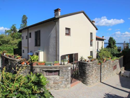 a house with a stone wall at Apartment Lo Scoiattolo by Interhome in Belgirate