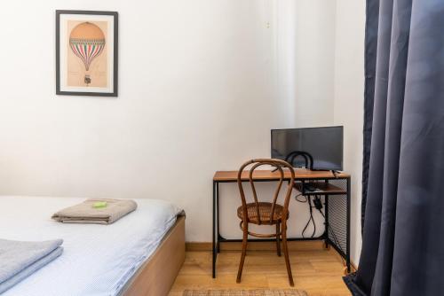 - une chambre avec un bureau et un lit avec une chaise dans l'établissement Chez Léo, Charme et Confort 5 min Gare 10 min Vieux Port, à Marseille