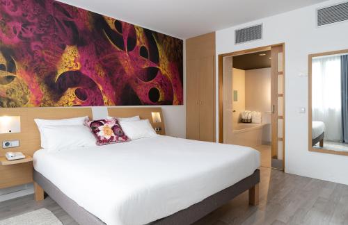 a bedroom with a bed and a painting on the wall at Novotel Barcelona Cornellà in Cornellà de Llobregat