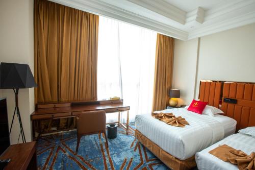 a hotel room with two beds and a desk and a desk at Hôtel Fleur de Lys Point E in Dakar