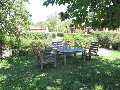 a picnic table and chairs in the grass at Holiday Home Stegeborg Sjöstugan by Interhome in Norrkrog