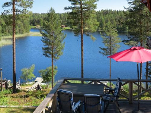 stół i krzesła na tarasie z widokiem na jezioro w obiekcie Chalet Nedre Gärdsjö - DAN085 by Interhome w mieście Rättvik