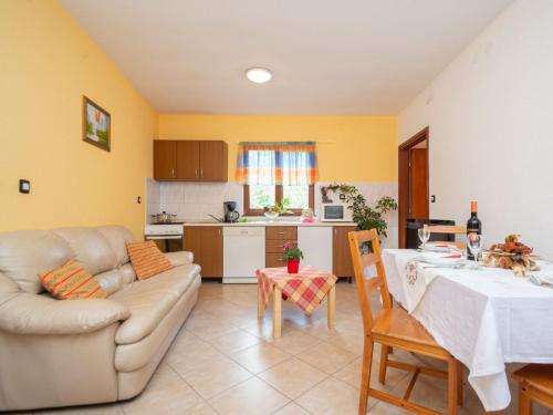 eine Küche und ein Wohnzimmer mit einem Tisch und einem Sofa in der Unterkunft Holiday Home Kristina - ROJ427 by Interhome in Žminj