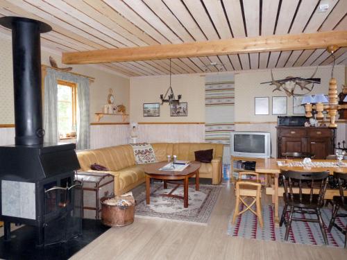 a living room with a couch and a stove at Chalet Vemhån Östholmen - HJD061 by Interhome in Vemhån
