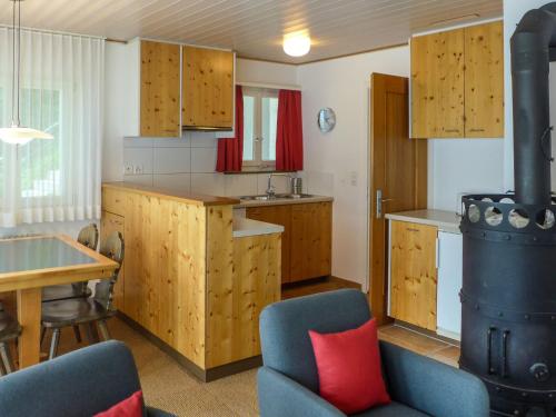 een keuken met houten kasten en een tafel en stoelen bij Apartment Chalet Holzwurm-1 by Interhome in Grindelwald