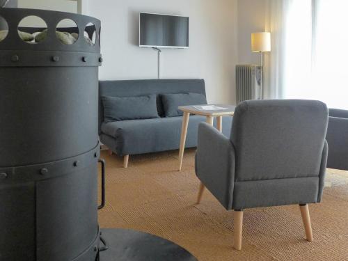 een woonkamer met een bank, een stoel en een tafel bij Apartment Chalet Holzwurm-1 by Interhome in Grindelwald