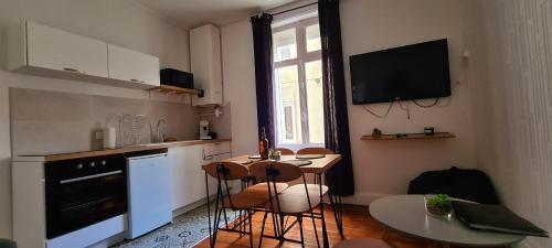 a kitchen with a small table and a kitchen with a television at Wimereux 30m2 1 chambre et 1 canapé lit à 2 pas de la plage et du centre in Wimereux