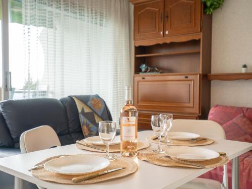 uma mesa com uma garrafa de vinho e copos em Apartment Fleurie I by Interhome em La Grande-Motte