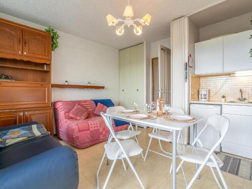 un salon avec une table, des chaises et un canapé dans l'établissement Apartment Fleurie I by Interhome, à La Grande Motte