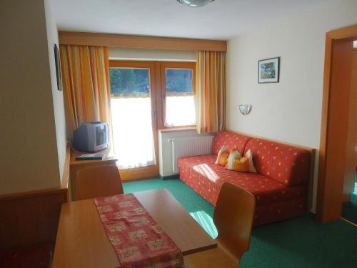 a living room with a red couch and a table at Apartment Köfels-5 by Interhome in Köfles