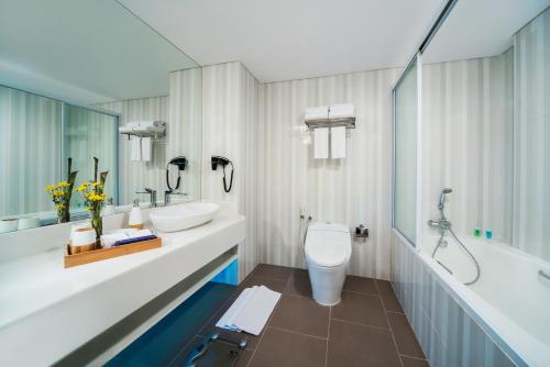 a bathroom with two sinks and a tub and a toilet at Blue Sky Hotel Petamburan in Jakarta