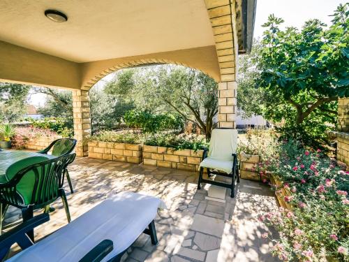 a patio with a table and chairs and flowers at Apartment Marija by Interhome in Vir