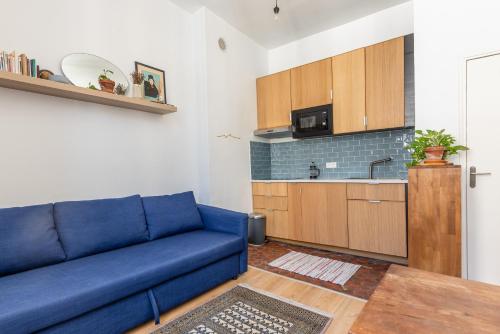 un salon avec un canapé bleu et une cuisine dans l'établissement Chez Léo, Charme et Confort 5 min Gare 10 min Vieux Port, à Marseille