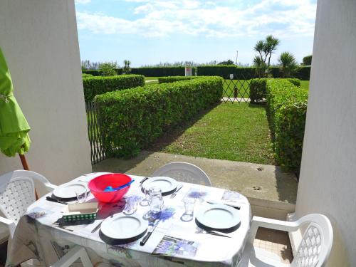 a white table with plates and glasses on a patio at Apartment Les Belles Plages-5 by Interhome in La Grande Motte