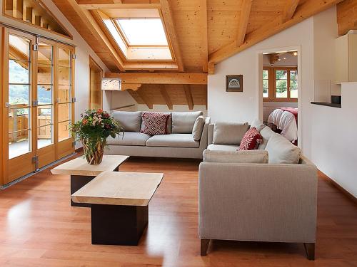 ein Wohnzimmer mit einem Sofa und einem Tisch in der Unterkunft Apartment Chalet Tuftstein by Interhome in Grindelwald