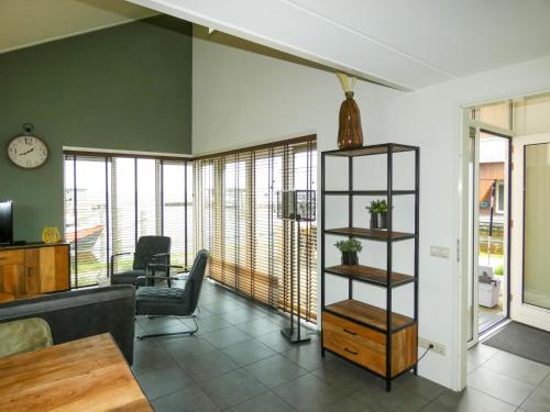 een woonkamer met een bank en een tafel bij Holiday Home De Meerparel by Interhome in Uitgeest