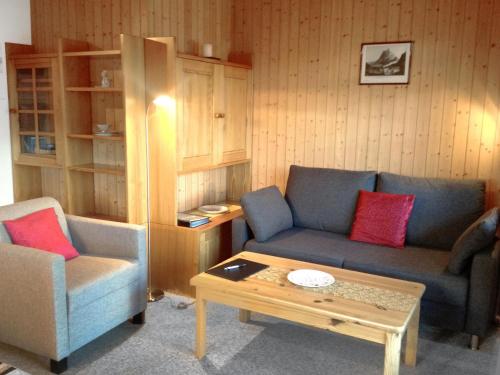 uma sala de estar com um sofá e uma mesa de centro em Apartment Lohnerhus-1 by Interhome em Grindelwald