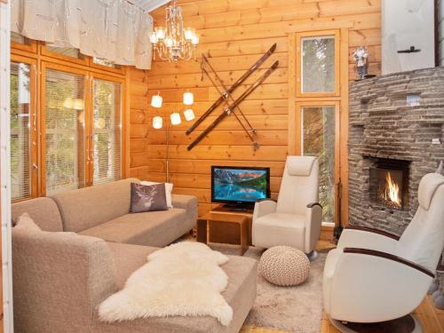 ein Wohnzimmer mit einem Sofa und einem Kamin in der Unterkunft Holiday Home Vuosseli-kelkka 15a by Interhome in Ruka