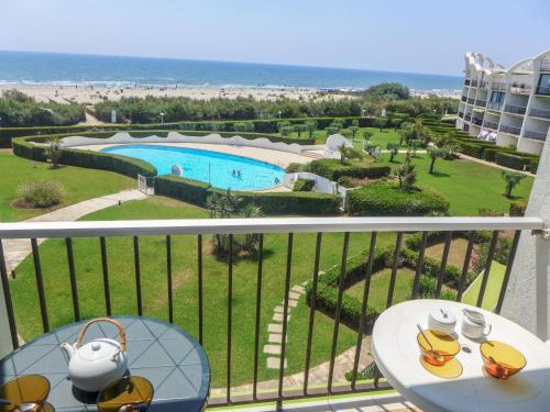 d'un balcon avec une table et une vue sur la piscine. dans l'établissement Studio Les Belles Plages-6 by Interhome, à La Grande Motte