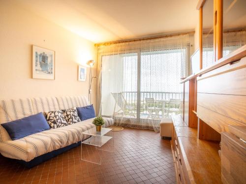 un salon avec un canapé et une grande fenêtre dans l'établissement Studio Les Belles Plages-6 by Interhome, à La Grande Motte