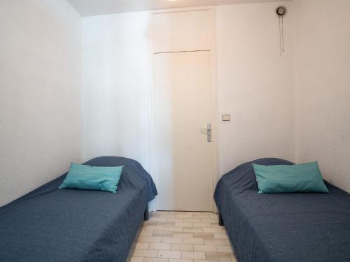 - 2 lits dans une chambre avec des oreillers bleus dans l'établissement Studio Les Terrasses de la Mer-14 by Interhome, à La Grande Motte