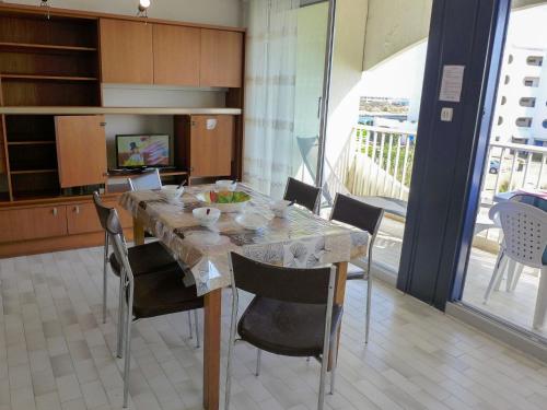 une salle à manger avec une table et des chaises et une cuisine dans l'établissement Studio Les Terrasses de la Mer-14 by Interhome, à La Grande Motte