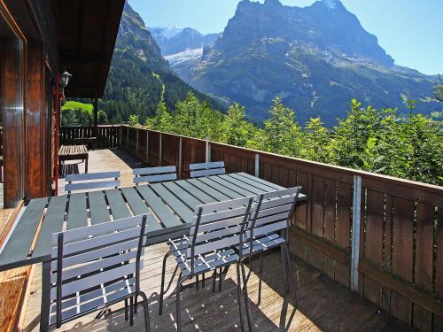 un tavolo e delle sedie su un ponte con vista sulle montagne di Chalet Egg-Isch by Interhome a Grindelwald