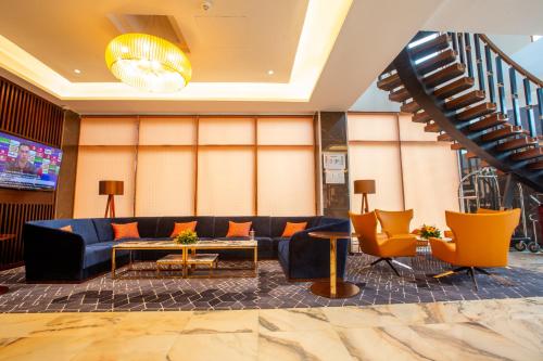a lobby with a blue couch and orange chairs at Hôtel Fleur de Lys Point E in Dakar