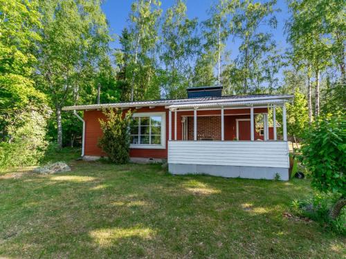 a small red and white house in a yard at Holiday Home Lampaluodon punainen tupa by Interhome in Tyltty