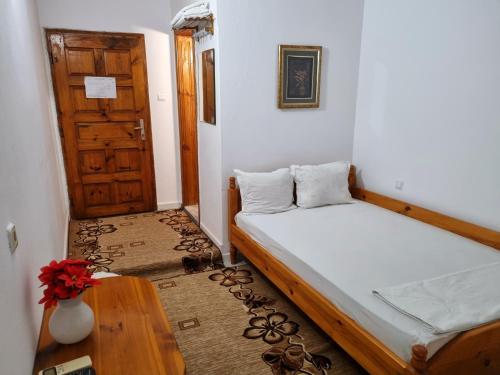 a room with a bed and a table and a door at Motel Thessaloniki in Sandanski
