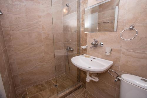 ein Badezimmer mit Waschbecken und Dusche in der Unterkunft Amfibia Beach Complex in Sonnenstrand