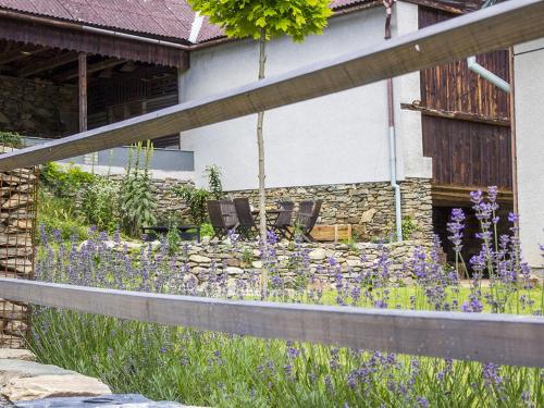 a garden with purple flowers in front of a house at Holiday Home Brníčko by Interhome in Brníčko