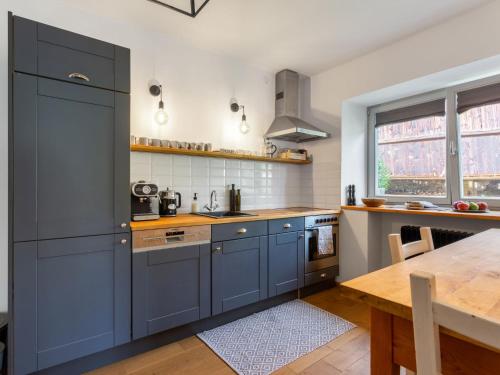 a kitchen with blue cabinets and a wooden table at Holiday Home Brníčko by Interhome in Brníčko