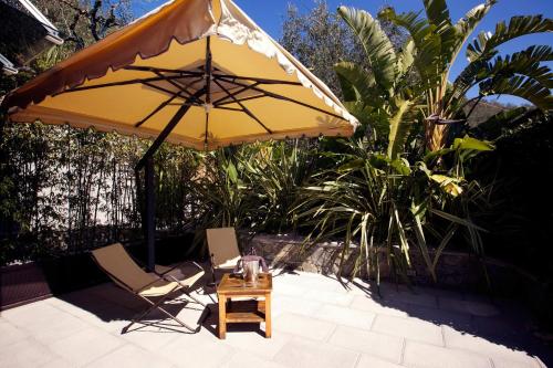 a yellow umbrella and two chairs and a table at B&B Il Parco in Monterosso al Mare